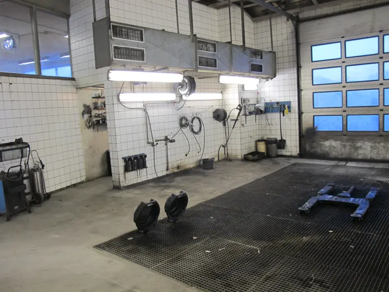 Værkstedshal med flisebelagte vægge og porte